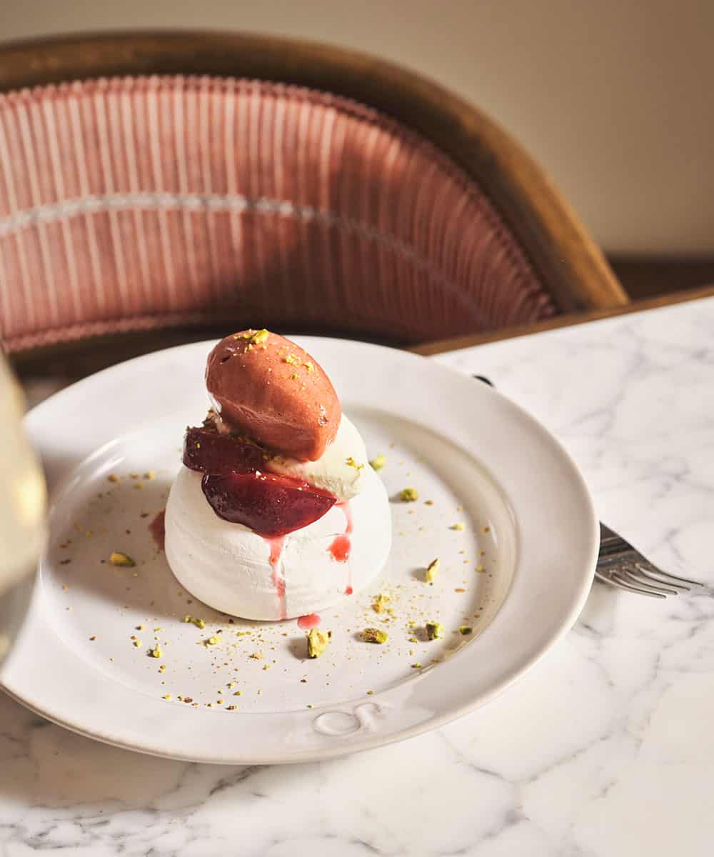 Plum pavlova. Meringue topped with poached plum and a sweet plum sauce.